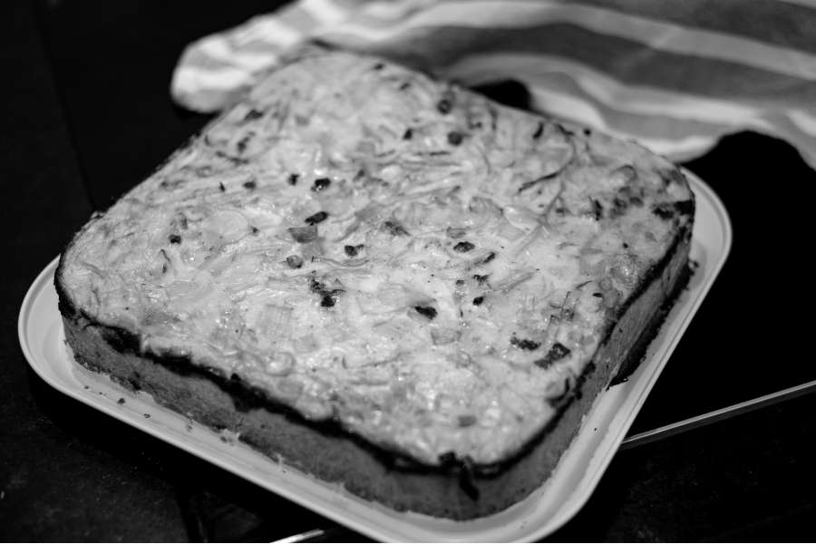 Rezept Foto Lauchzwiebelkuchen backen und genießen. Der fertige, dampfende Lauchzwiebelkuchen kommt gerade aus dem Ofen und ist goldbraun gebacken.
