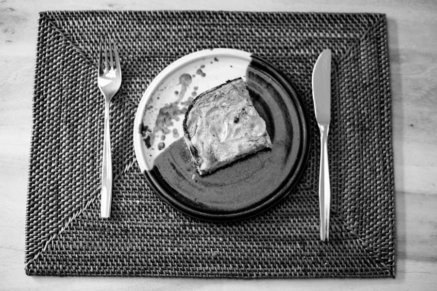 Rezept Foto Lauchzwiebelkuchen backen und genießen. Ein Stück Lauchzwiebelkuchen wurde auf einem kleinen blauen Tonteller angerichtet und mit Salz und Pfeffer bestreut.