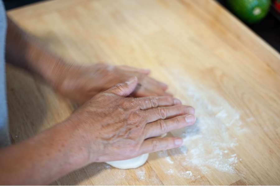Rezept Foto Oberpfälzer Milchrahm Apfelstrudel. Mama Siglinde knetet den Teig nachdem rühren mit den Händen.