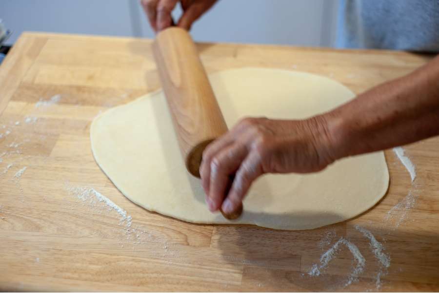 Rezept Foto Oberpfälzer Milchrahm Apfelstrudel. Mama Siglinde rollt den Teig mit einem Nudelholz aus.