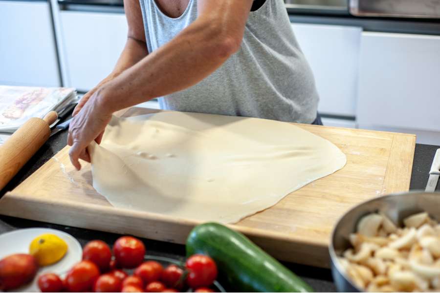 Rezept Foto Oberpfälzer Milchrahm Apfelstrudel. Mama Siglinde breitet den Teig mit den Händen aus, damit er gleich befüllt werden kann.