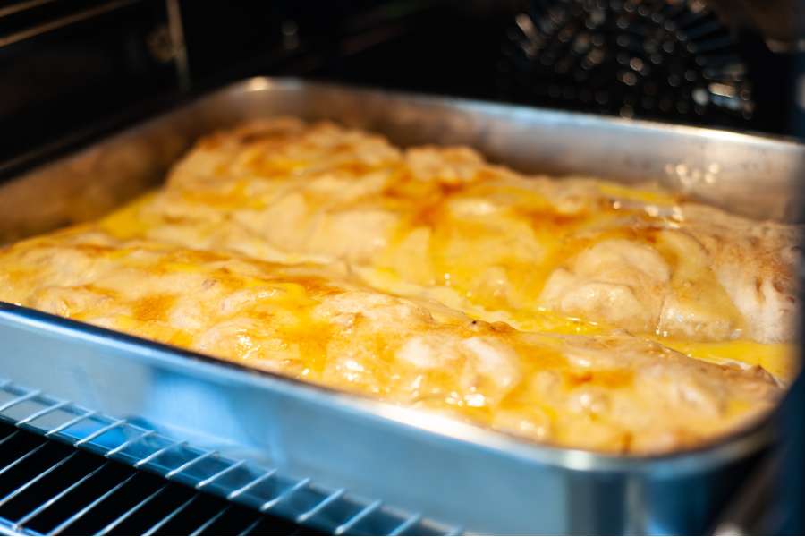 Rezept Foto Oberpfälzer Milchrahm Apfelstrudel. Der Strudel backt im Ofen seit kurzer Zeit, das Ei stockt langsam und die Oberfläche wird gold braun.
