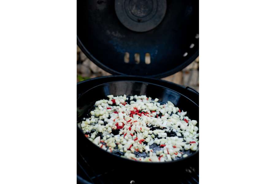 Rezept Foto Mexikansiche Enchillada. Erst werden die Zwiebel und die Chillis auf der Grillpfanne auf dem Gasgrill angebruzzelt.