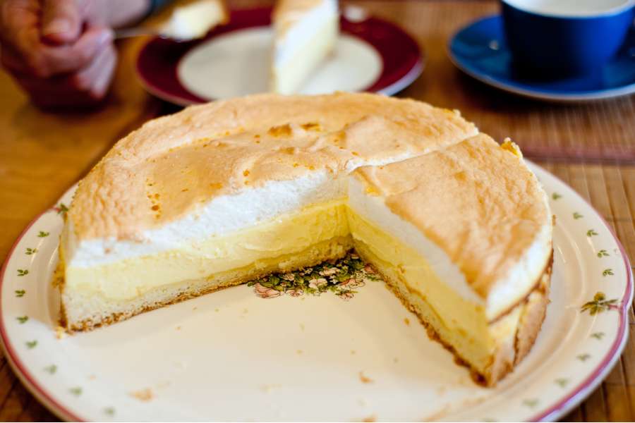 Rezept Foto Tröpfchenkuchen. Der Eischnee wird mit einem Schaumlöffel auf der Oberfläche vorsichtig verteilt.